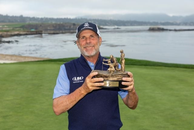 Professional golfer Doug Barron smiles while holding his bronze PURE Insurance Championship trophy