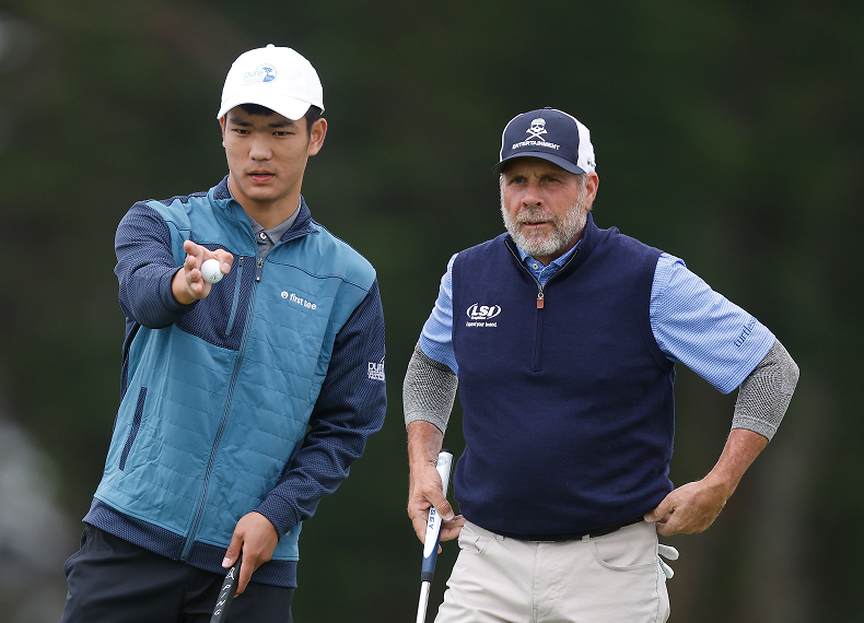 A First Tee junior golfer points out a ball to a professional golfer during a tournament round