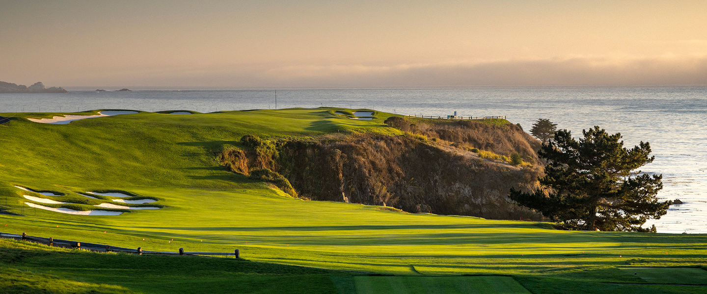 Dramatic sunset view of rolling green fairways on the cliffs of Pebble Beach overlooking the Pacific