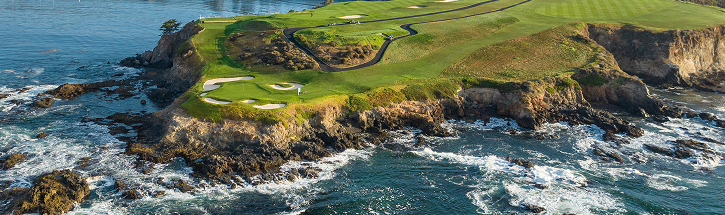 Aerial view of the rugged Pebble Beach coastline and green fairways meeting the Pacific Ocean waves