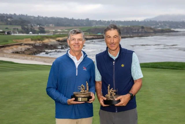 Rich Petit and Avie Tevanian smiling while holding their bronze tournament trophies near the coast