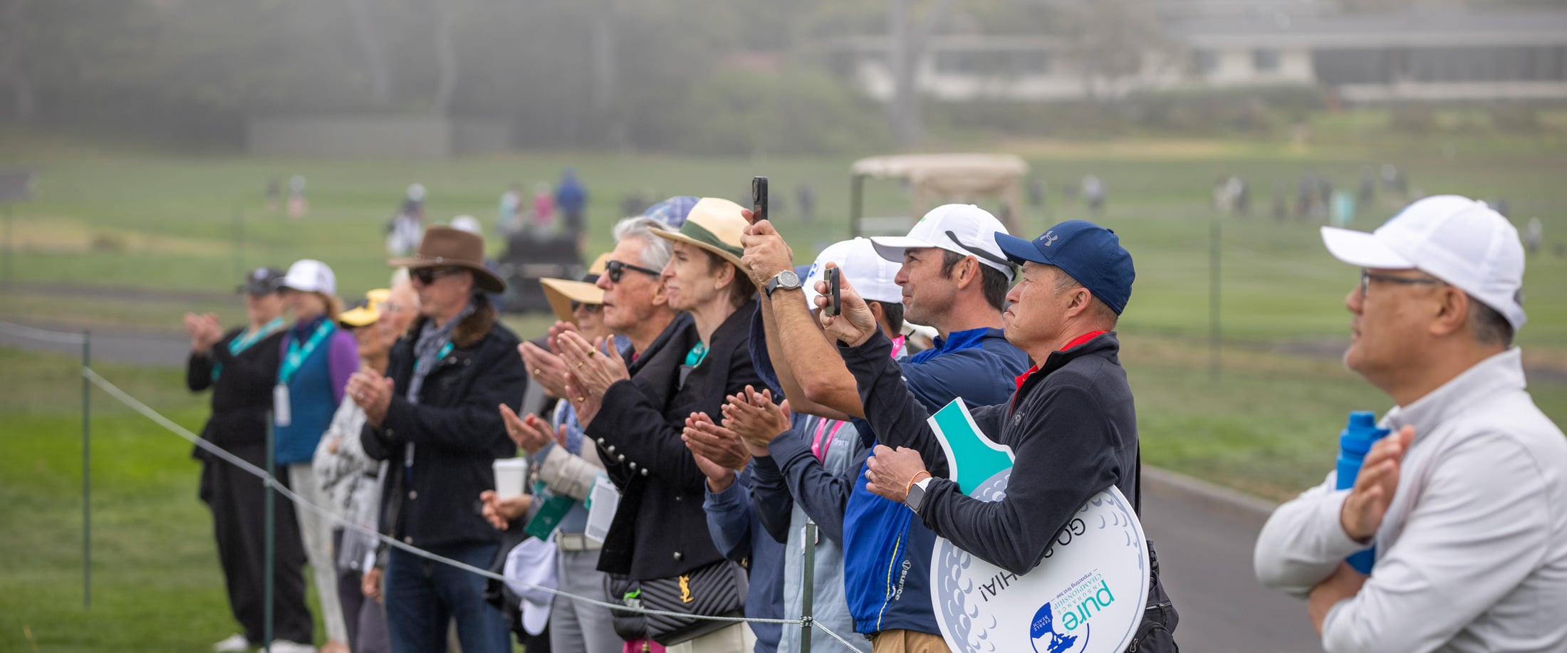 Spectators clapping as they watch the PURE Insurance Championship tournament
